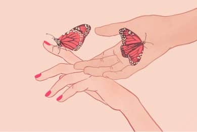 Dwie dłonie, na których siedzą motyle.