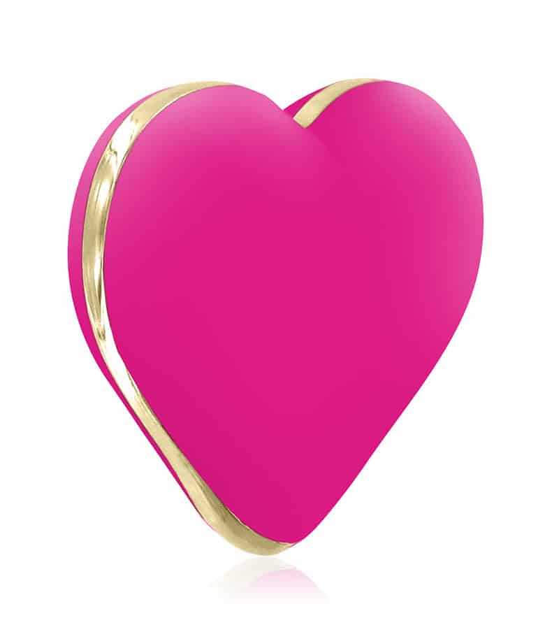 Różowy masażer Rianne S Heart Vibe o spłaszczonym kształcie serca, ze złotą obwódką ciągnącą się po bocznej krawędzi.