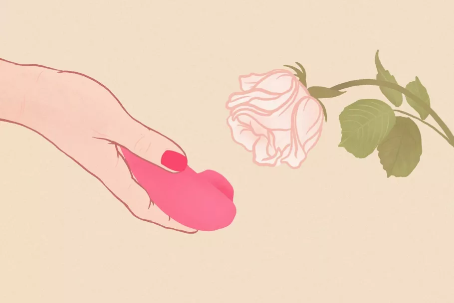 Na rysunku dłoń trzyma czerwony, bezdotykowy masażer łechtaczki skierowany w stronę białego kwiatu róży.