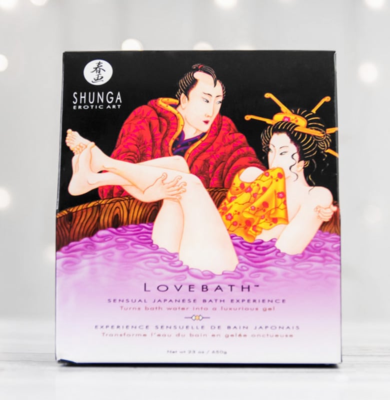 Opakowanie zestawu do żelowej kąpieli Shunga Lovebath z rysunkiem mężczyzny wkładającego kobietę do wanny.