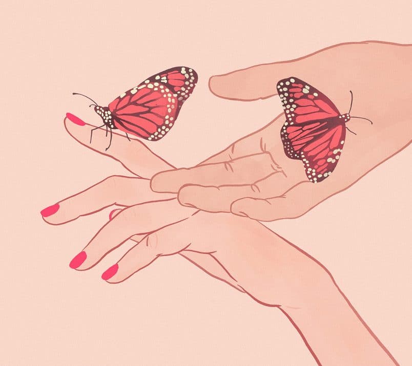Dwie dłonie, na których siedzą motyle.