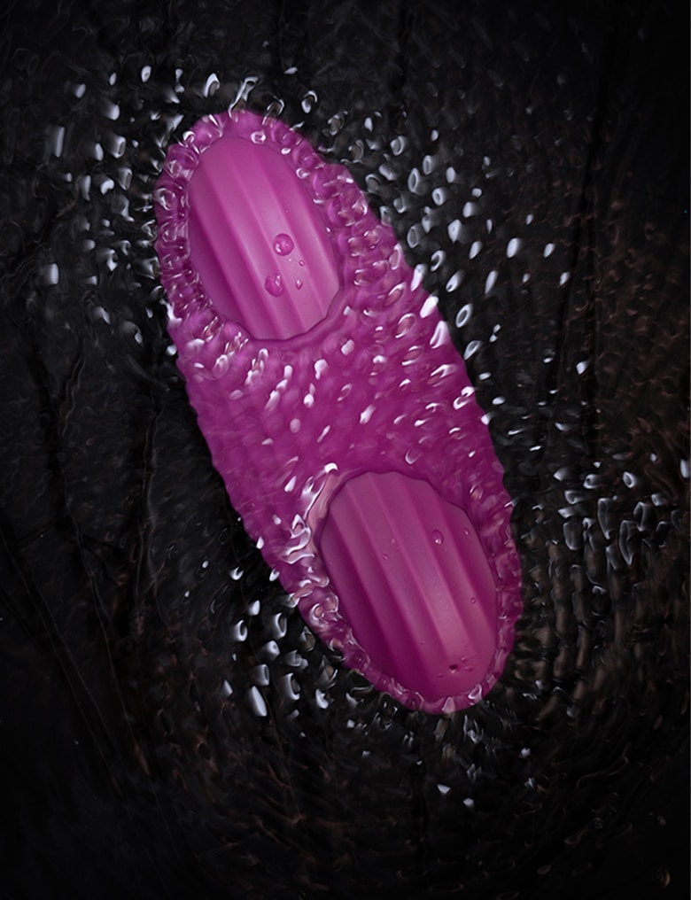 Fioletowy masażer Svakom Edeny wibruje częściowo zanurzony w wodzie, tworząc kręgi na jej powierzchni.