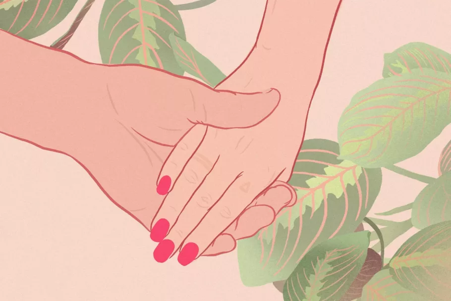 Dłoń z czerwonymi paznokciami leży w większej dłoni drugiej osoby na tle liści maranty.